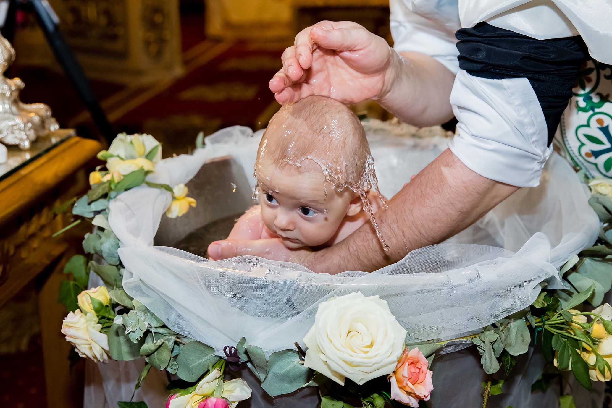 copil stropit cu apa la botez in biserica in bucuresti